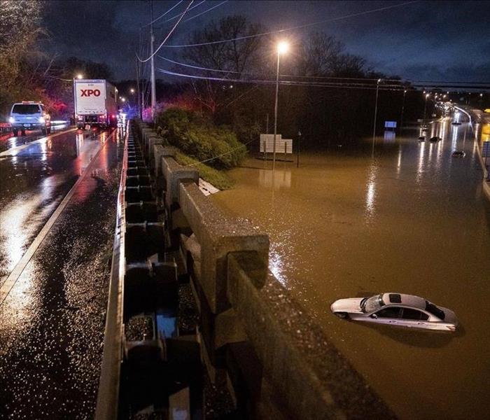 night time cars on highway with car trapped in flood waters
