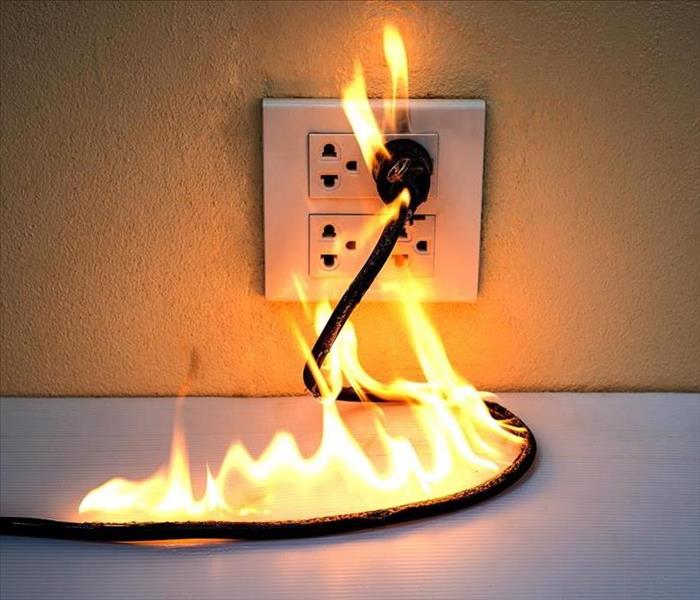 Electrical outlet and cord on fire
