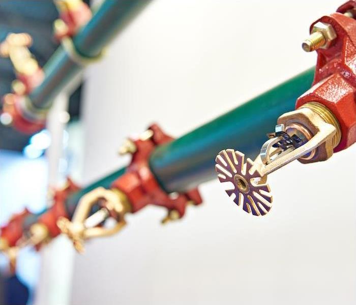 a red and green commercial sprinkler system hanging near ceiling of building